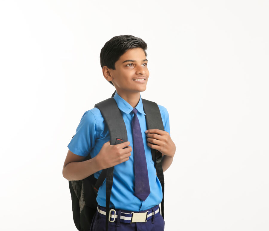 Indian school boy standing on white background.